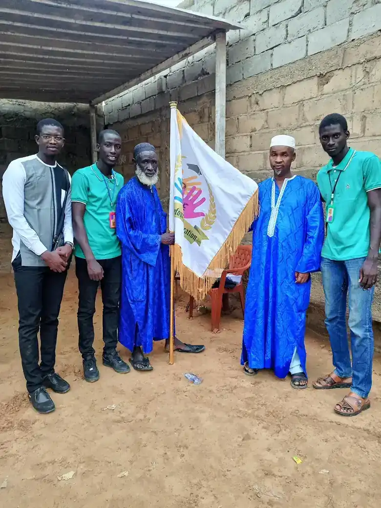 Missionnaires du CDE avec le Serigne Daara et l'imam du village, drapeau du CDE