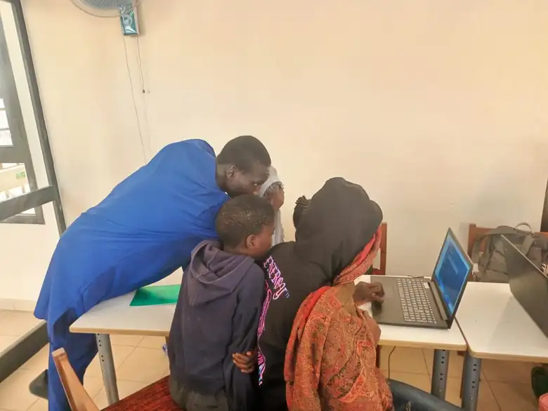 Encadrant du CDE accompagnant des enfants sur un ordinateur portable