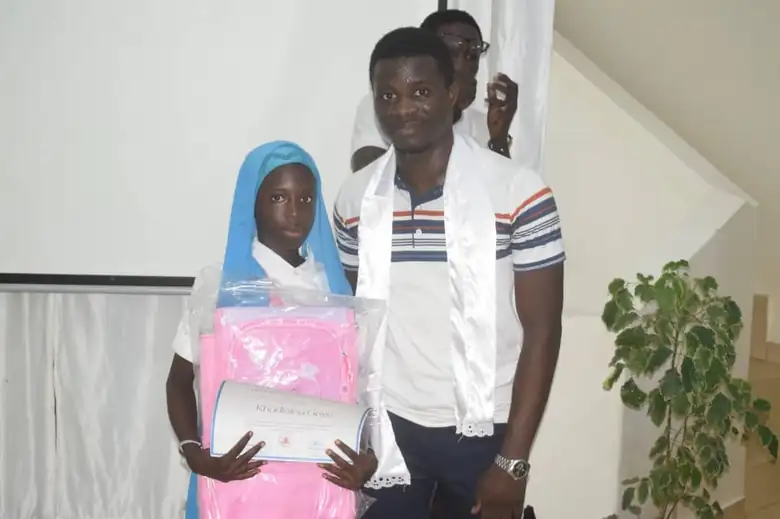 Remise d'un kit scolaire et d'une attestation à une élève lauréate