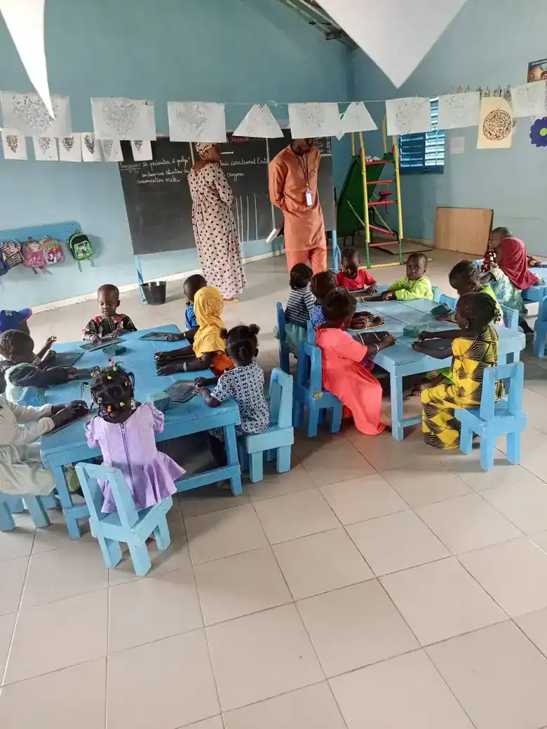 Jeunes enfants réunis autour d'une table dans une case des tout-petits à Goudiabya