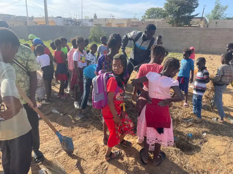 Enfants du quartier participant à une opération de salubrité